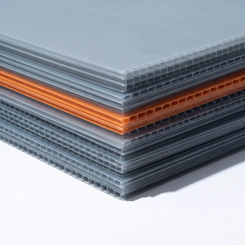 A stack of flat twin-wall polypropylene layer pads, grey-blue with an orange pair part way down.